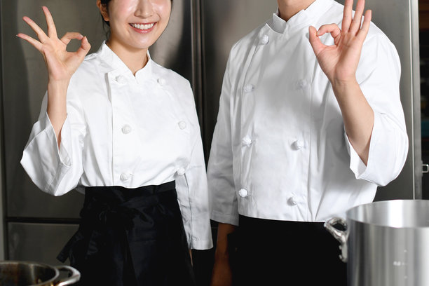 年轻的亚洲女厨师和男厨师在厨房里给出OK的手势图片下载