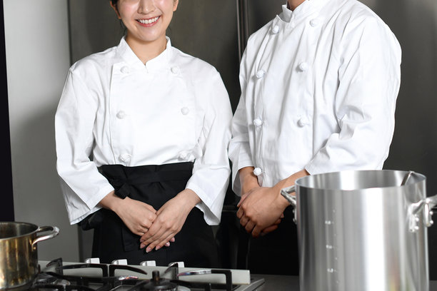 年轻的亚洲男女厨师在厨房的大锅里做饭图片下载