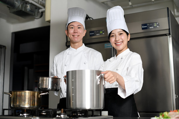 年轻的亚洲男女厨师在厨房的大锅里做饭图片下载