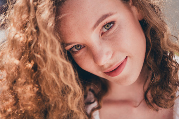 照片中的兴奋梦幻的女士看着镜头，穿着白衬衫走在现代城市街道外图片下载