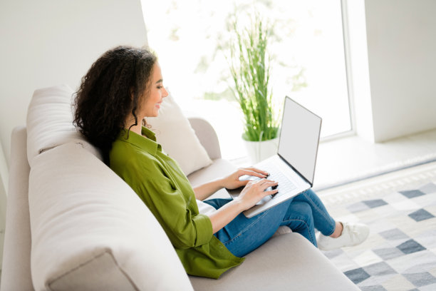 可爱可爱的女孩的照片坐在舒适的沙发上使用无线上网本工作从家里平周末在室内图片下载