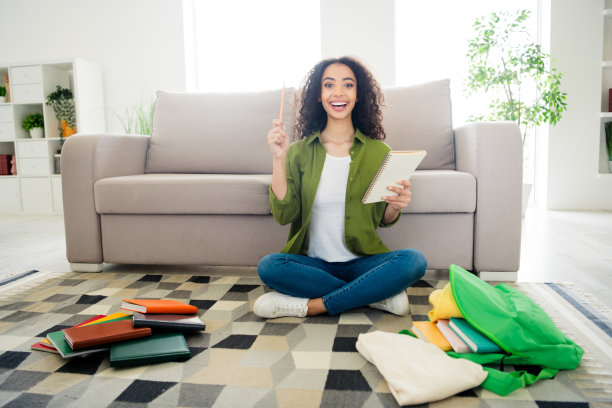 可爱、聪明、聪明的女孩坐在地板上写计划，在室内准备大学教育讲座背包的照片图片下载