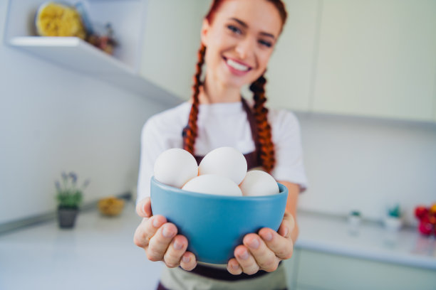 可爱的家庭主妇展示鸡蛋，在自家厨房烹饪美味晚餐的照片图片下载