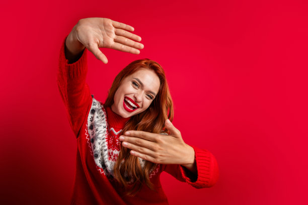 年轻时髦的内容制造商女孩的肖像做事件照片会议演示框架手势与她的手孤立的红色背景图片下载