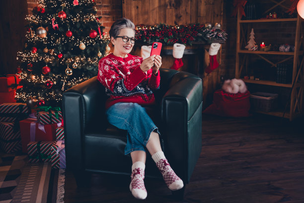 可爱积极的女人戴着红色印花圣诞毛衣眼镜的照片收到圣诞短信instagram twitter电报facebook在室内公寓房间图片下载