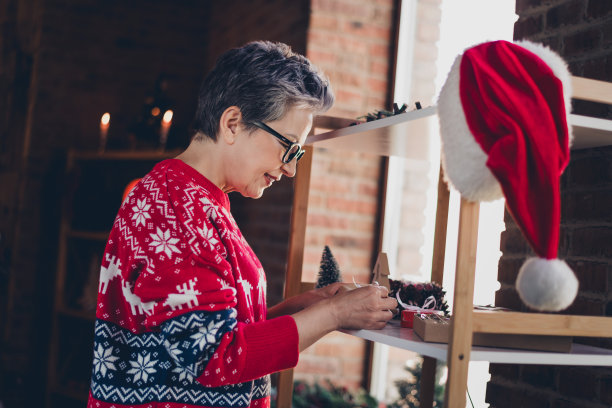 正老年人的头像在室内准备圣诞礼物架圣诞老人头饰公寓图片下载