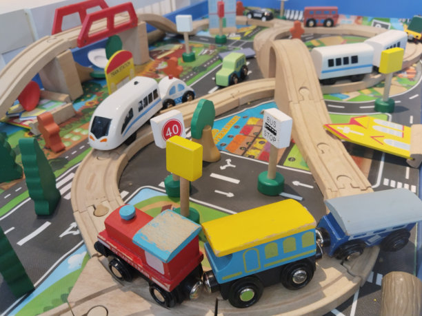 一群儿童玩具火车散落在木制轨道上。图片下载