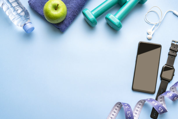 健康的生活方式和健身背景。智能手表，手机，哑铃，耳机，卷尺图片下载