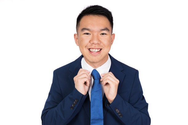 一个西装革履的年轻人正微笑着整理领带图片下载