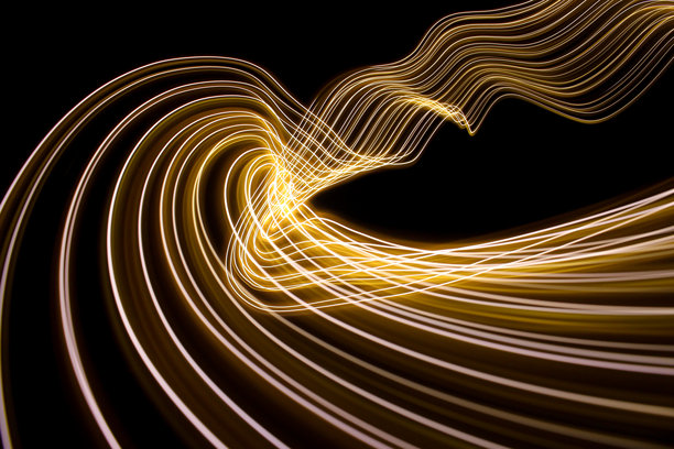 长时间曝光的照片。光画摄影-在黑色背景下，霓虹灯金色的漩涡波图片下载
