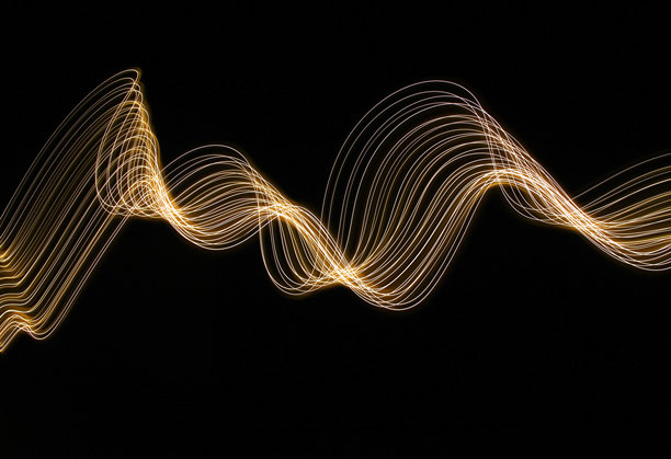 长时间曝光的照片。光画摄影-在黑色背景下，霓虹灯金色的漩涡波图片下载