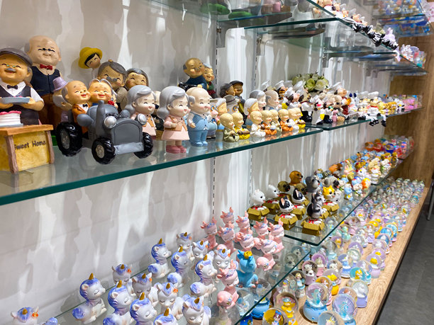 玻璃架子上陈列着五颜六色的小雕像和雪花玻璃球图片下载