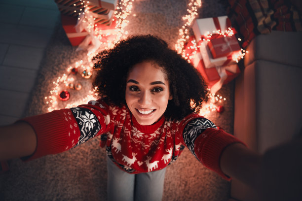 迷人的年轻女子的照片自拍微笑穿着装饰服装舒适的新年装饰花环家室内客厅图片下载