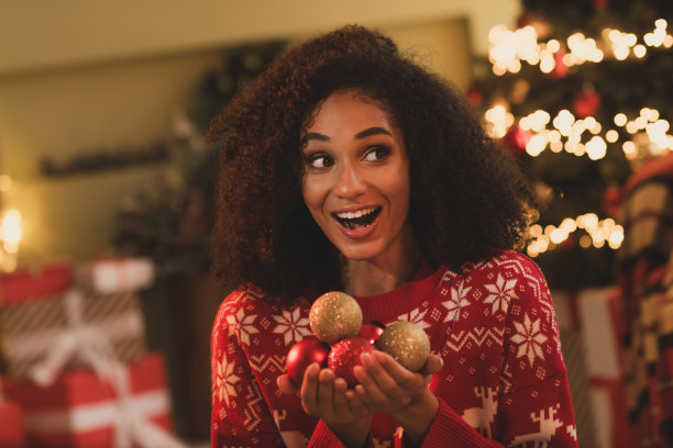 照片开朗的女孩看起来兴奋空旷的空间装饰树球穿着装饰服装舒适的圣诞派对装饰房子室内房间图片下载