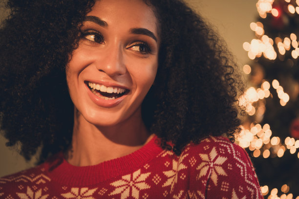 迷人的年轻女孩的照片开朗的看着空旷的空间穿着装饰装备舒适的新年装饰花环家室内客厅图片下载