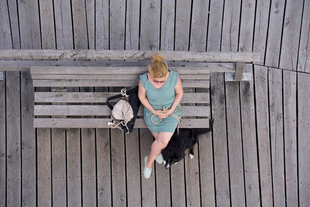 正上方的照片是狗坐在木凳上的女人图片下载