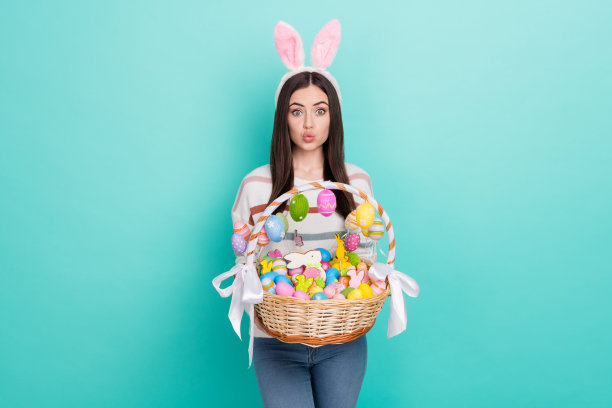 照片兴奋轻浮的女士穿着条纹套头衫有发带持有彩色复活节篮子孤立蓝绿色背景图片下载