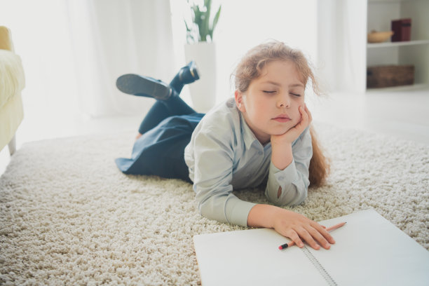 迷人的困倦女孩的照片学习者躺着地毯家庭作业家庭作业舒适的家庭房间室内日光室内图片下载