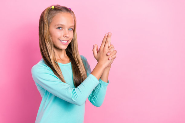 年轻的小的青春期前的女学生的照片持有抽象的手指手枪武器牙齿微笑自信俏皮孤立在明亮的粉红色背景图片下载