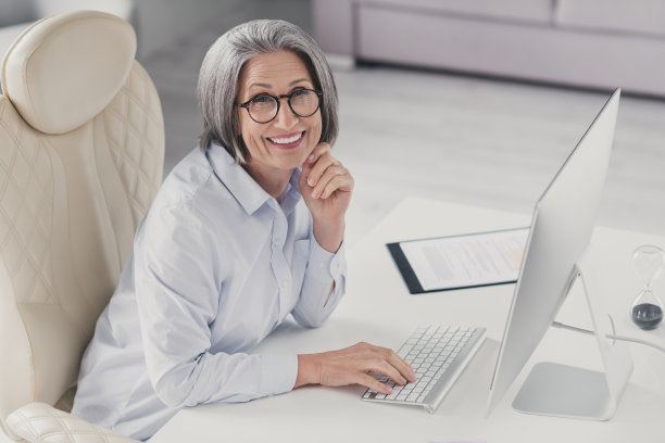 照片中，迷人的微笑女老板穿着白衬衫，戴着眼镜，在工作站车间欢迎新员工图片下载