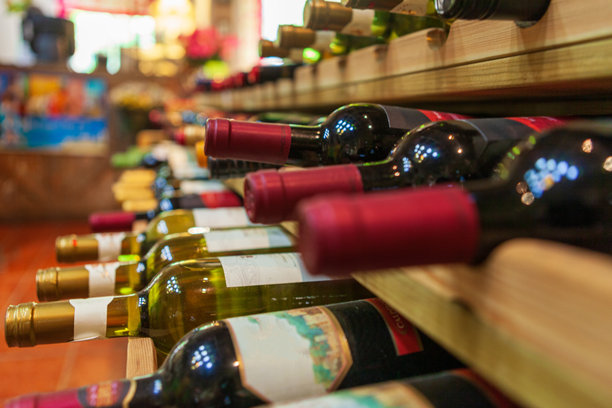 一个组织良好的酒架展示各种瓶子在一个舒适的葡萄酒商店设置图片下载