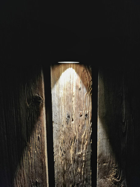 暗木背景上支架灯的光影。在墙上形成三角形的光形图片下载