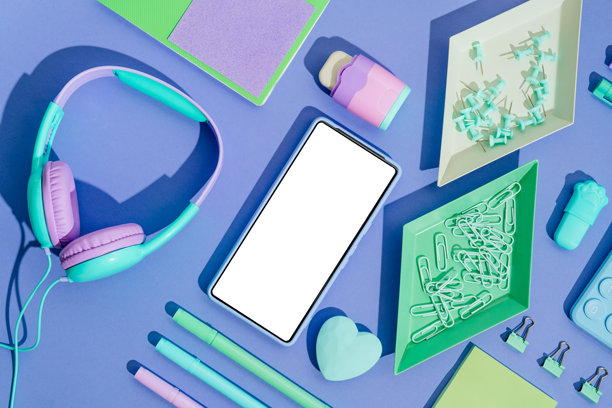 紫罗兰色背景与复印空间附近的电话和现代潮流明亮的办公用品图片下载