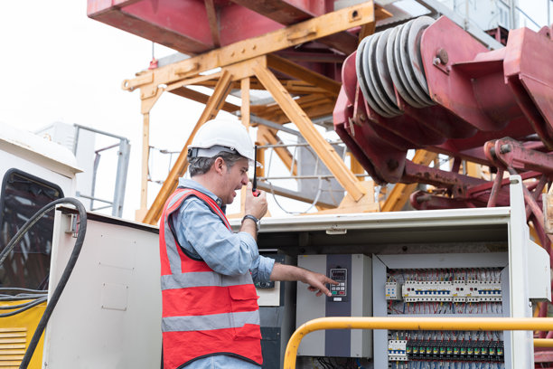 男电工负责起重机施工电气系统的检查、维修、维护。男电工在施工现场控制电气系统的操作图片下载