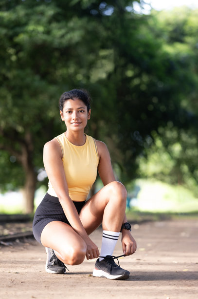 年轻的拉丁妇女在公园里为锻炼做热身图片下载