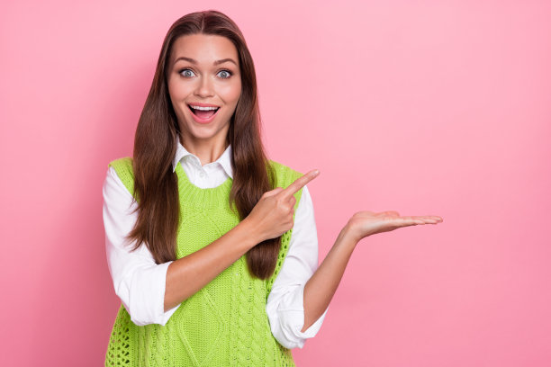 照片中，惊喜的女士穿着时尚的衣服，展示了黑色星期五的空空间折扣，粉红色的背景孤立图片下载