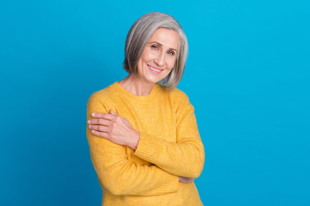 照片可爱开朗的人牙齿微笑，手拥抱肩膀孤立的蓝色背景图片下载