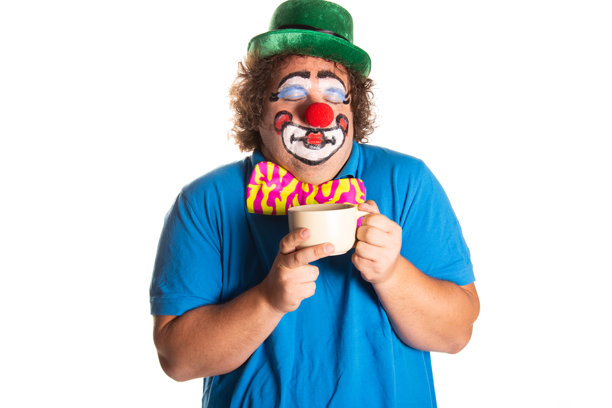 滑稽的胖小丑在白色背景上摆姿势。图片下载