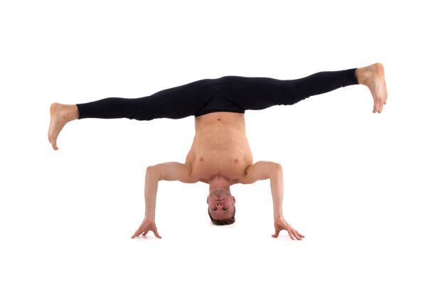 运动和健康的生活方式。一个有魅力的男人正在做普拉提。白色背景。图片下载