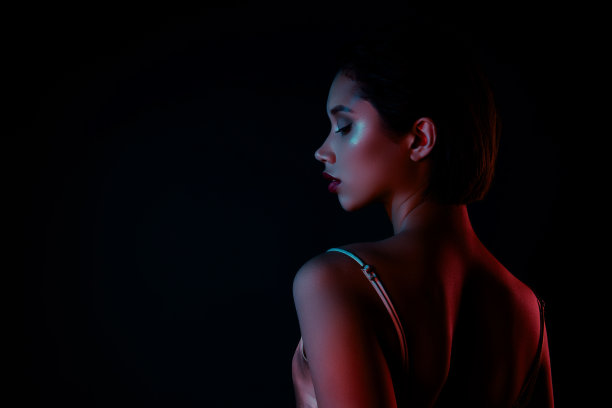 照片中快乐漂亮的女士穿着优雅的礼服享受着夜生活，空旷的空间孤立的黑色背景图片下载