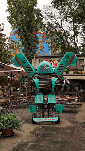 2023年10月7日，德国德累斯顿:在一家充满活力的咖啡馆Katys Garage，一个大型机器人雕塑与食客互动。垂直移动照片。sstkvertical图片下载