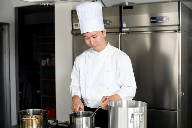 亚洲年轻男性厨师在厨房做饭图片下载