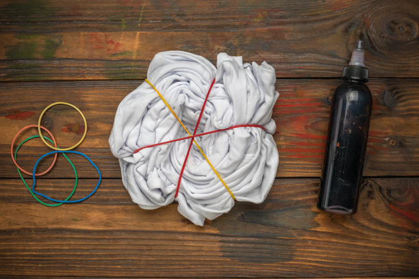 在木制表面上用白衬衫、染料瓶和橡皮筋DIY扎染准备图片下载