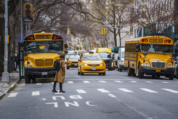 纽约上东区附近街道上典型的黄色校车和人群图片下载