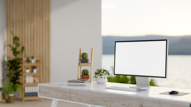 一张电脑桌的特写图片，在一个宽敞的、现代极简主义的房间里，可以看到自然景观。图片下载