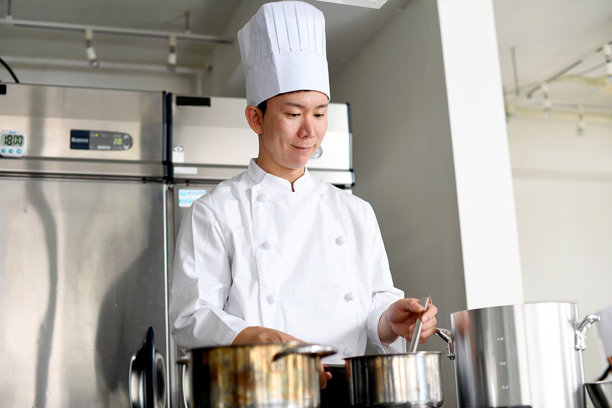 亚洲年轻男性厨师在厨房做饭图片下载