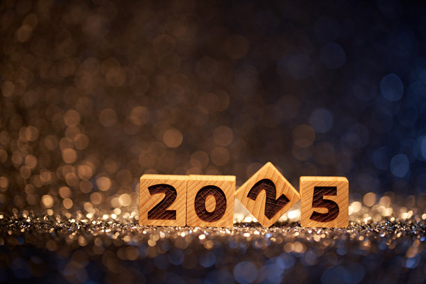 在闪闪发光的背景下，木制积木形成了2025，背景是散焦的节日灯光图片下载