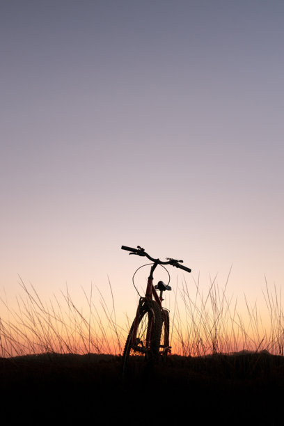 日落后天空下自行车的剪影。图片下载