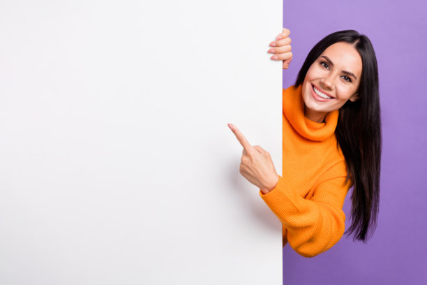 女士促销者的照片表明不可思议的广告点指白色的空白空间，在紫色背景上孤立的标牌图片下载