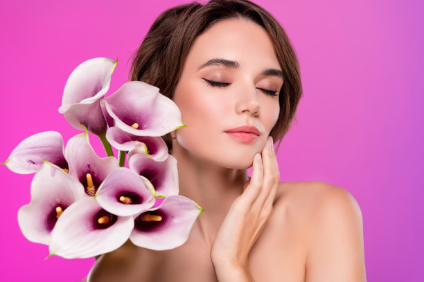 梦幻般的女人肩膀享受百合花束闭上眼睛孤立的霓虹粉色背景的照片图片下载