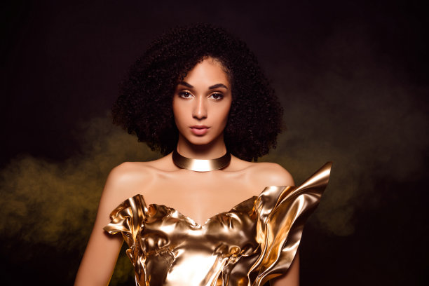 照片上迷人的女士女孩戴着闪闪发光的黄色裙子项链孤立的深色背景图片下载