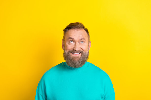 照片积极的男人穿明亮的青色运动衫感兴趣的看空空间新奇低价格孤立在黄色的背景图片下载