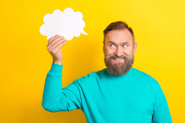 照片中，思想积极的男人穿着时髦的衣服，手拿纸卡，在黄色背景上显示出空白的空间图片下载