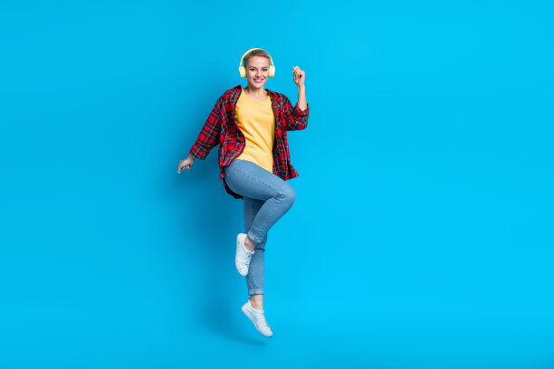 满意的自由女孩的全尺寸照片，短发型，穿着红色衬衫，在蓝色背景上飞行跳舞，玩得很开心图片下载