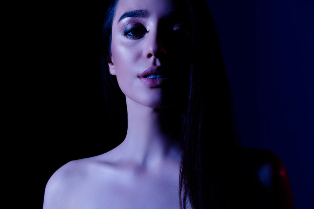 有吸引力的女孩的照片与烟熏眼感觉看起来诱人孤立的黑暗霓虹灯色背景图片下载