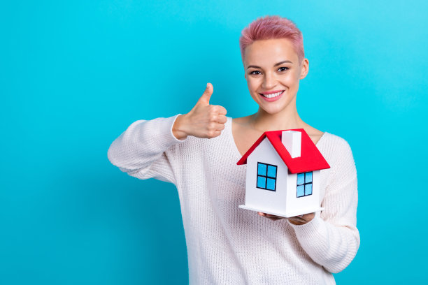 照片开朗的女商人粉红色短发房地产经理大拇指推荐机构购买新的公寓孤立的青色背景图片下载